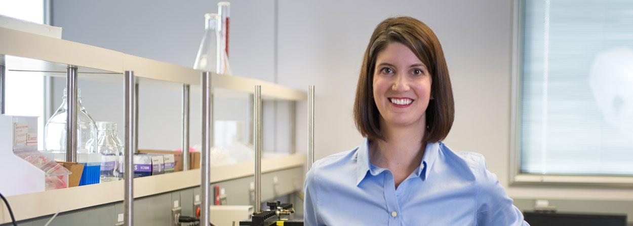 Dr. Nicole Brogden standing next to a lab bench in her lab